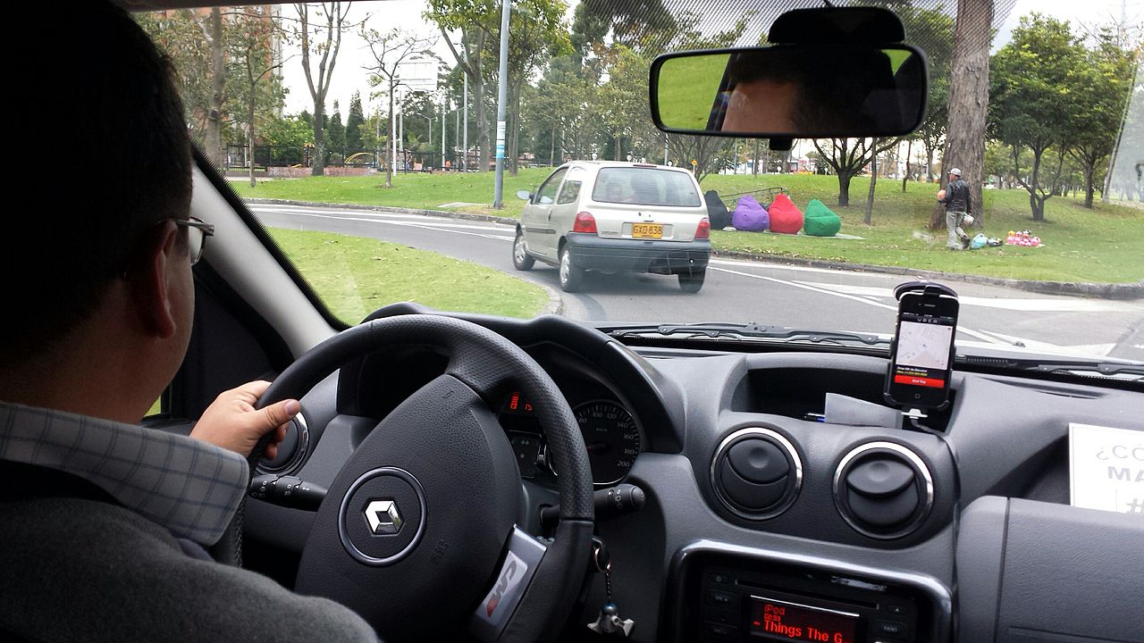 An Uber ride in Bogotá, Colombia. Visible on the dashboard is a phone running the Uber app. The app provides turn by turn navigation to the driver, and also provides information to Uber so the price of the trip can be calculated.